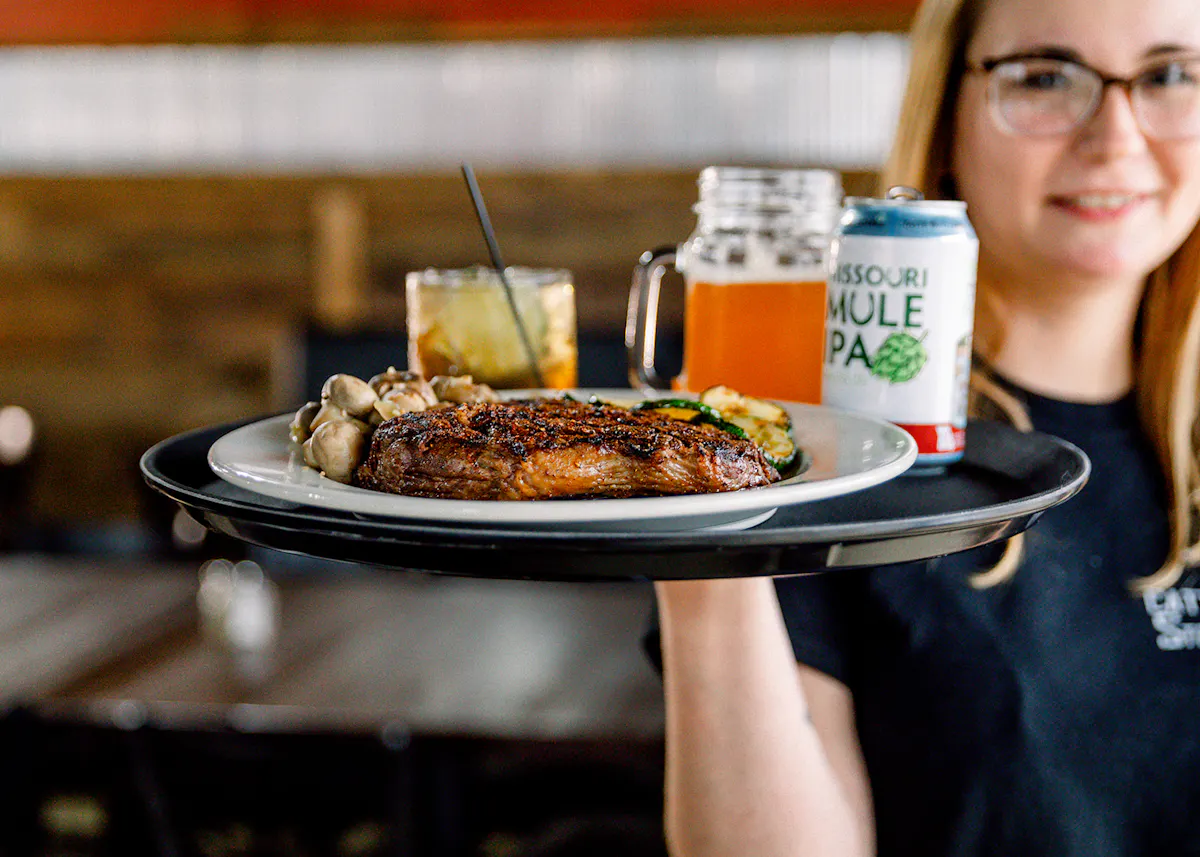 a woman sitting at a table with a plate of food