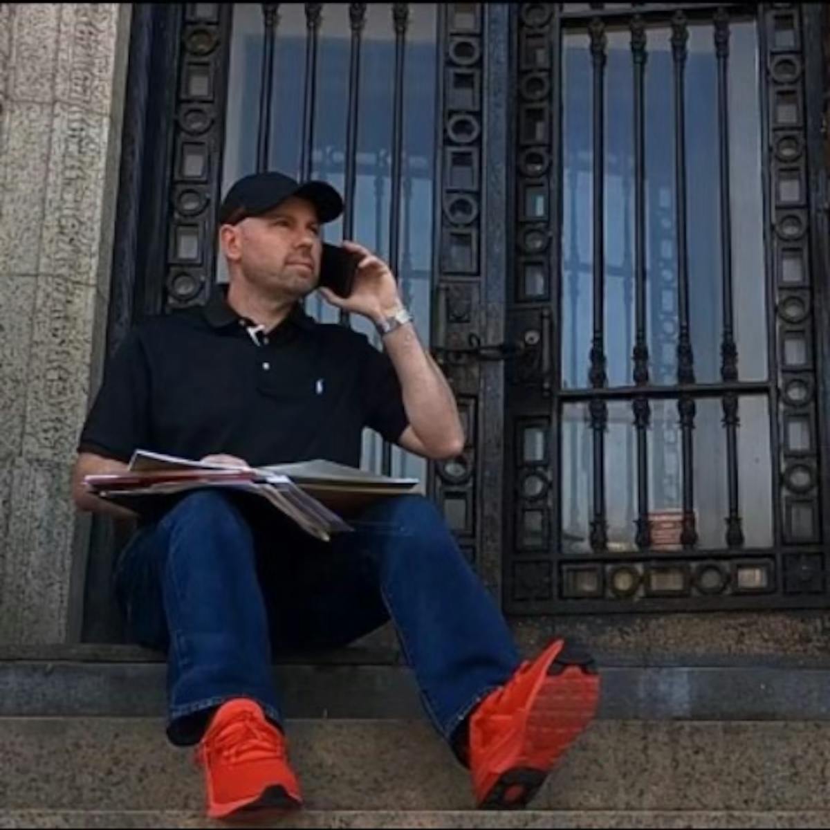 a man sitting on a bench in front of a building