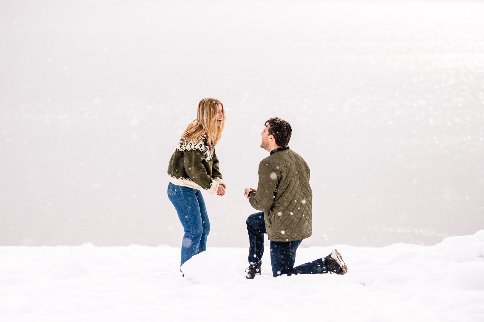 a person riding a snowboard down a snow covered slope