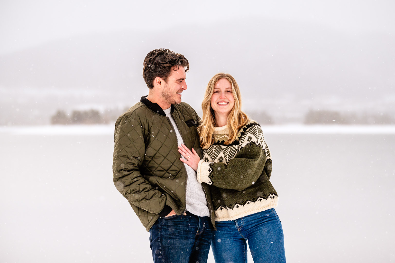 a person standing in front of a body of water posing for the camera