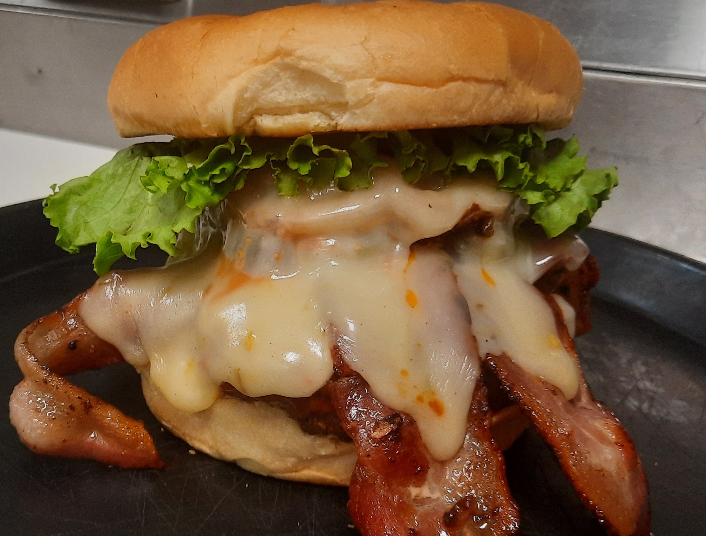 a close up of a sandwich with meat and vegetables