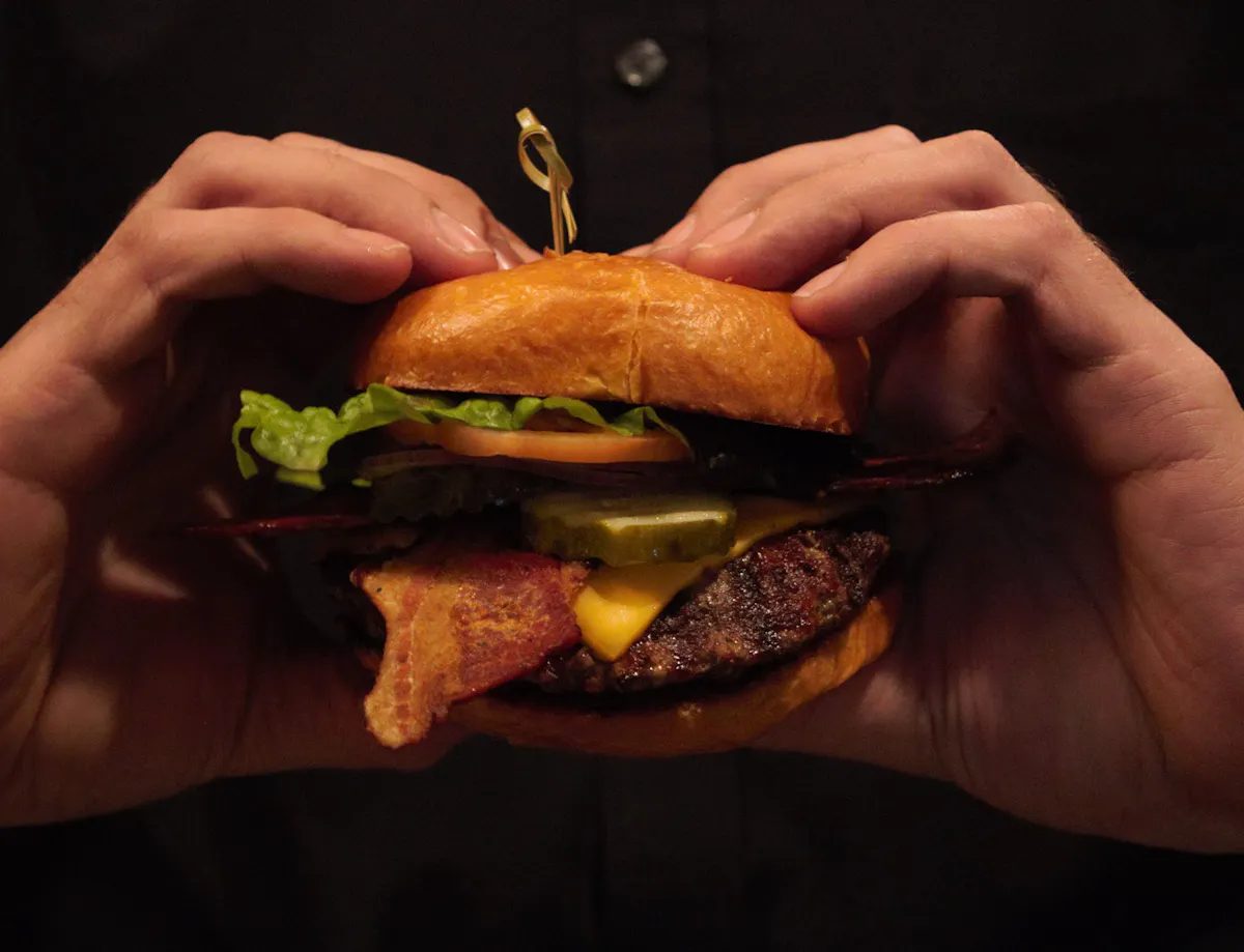 a close up of a person holding a sandwich in his hand