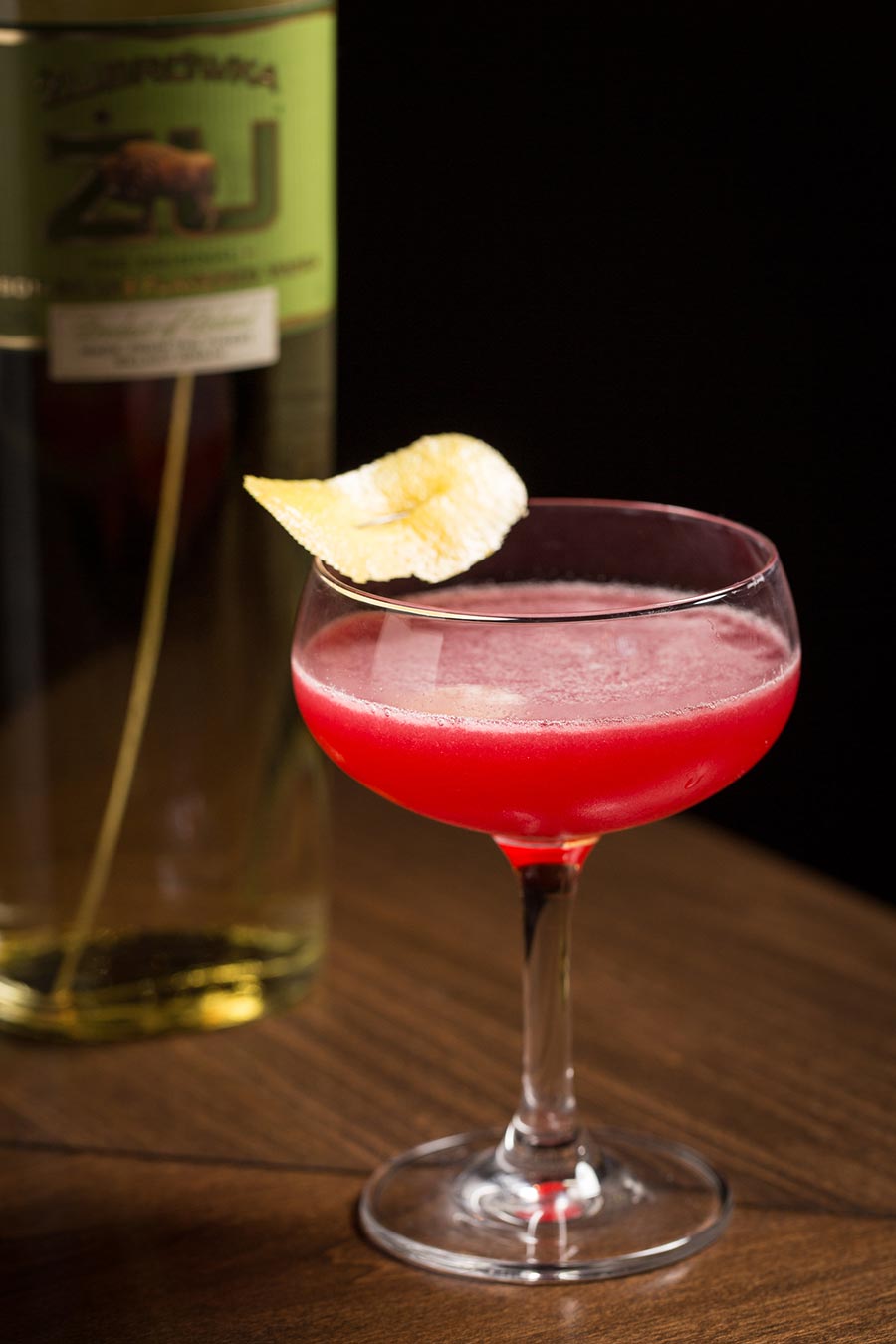 a glass of wine sitting on top of a wooden table