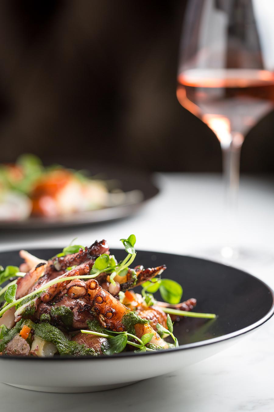 a plate of salad and a glass of wine