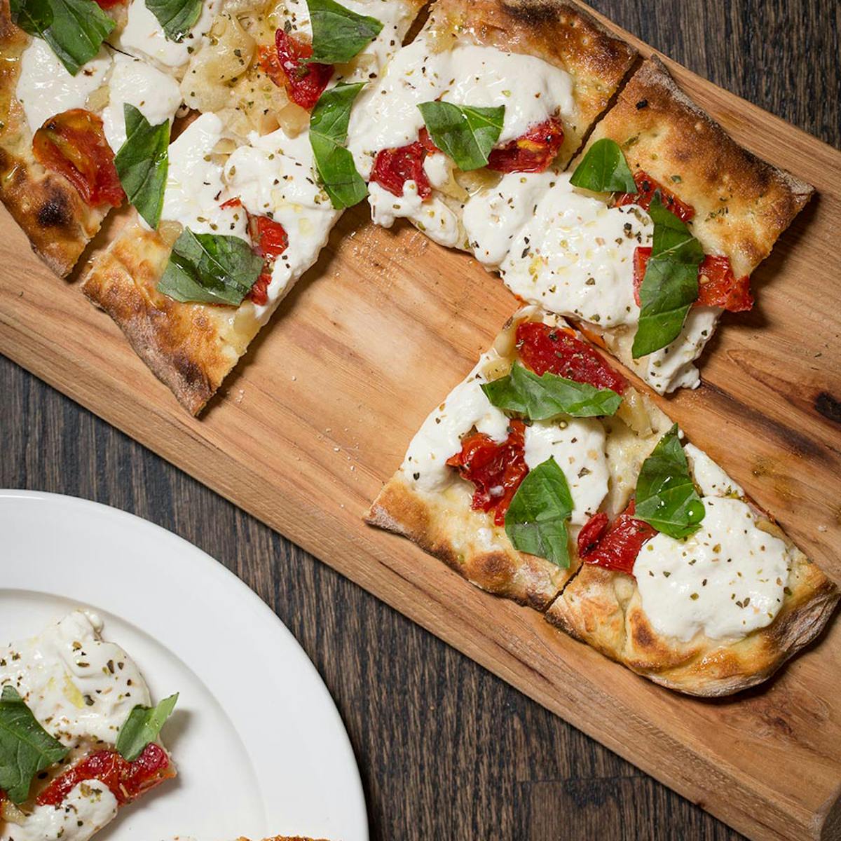 a slice of pizza sitting on top of a wooden cutting board