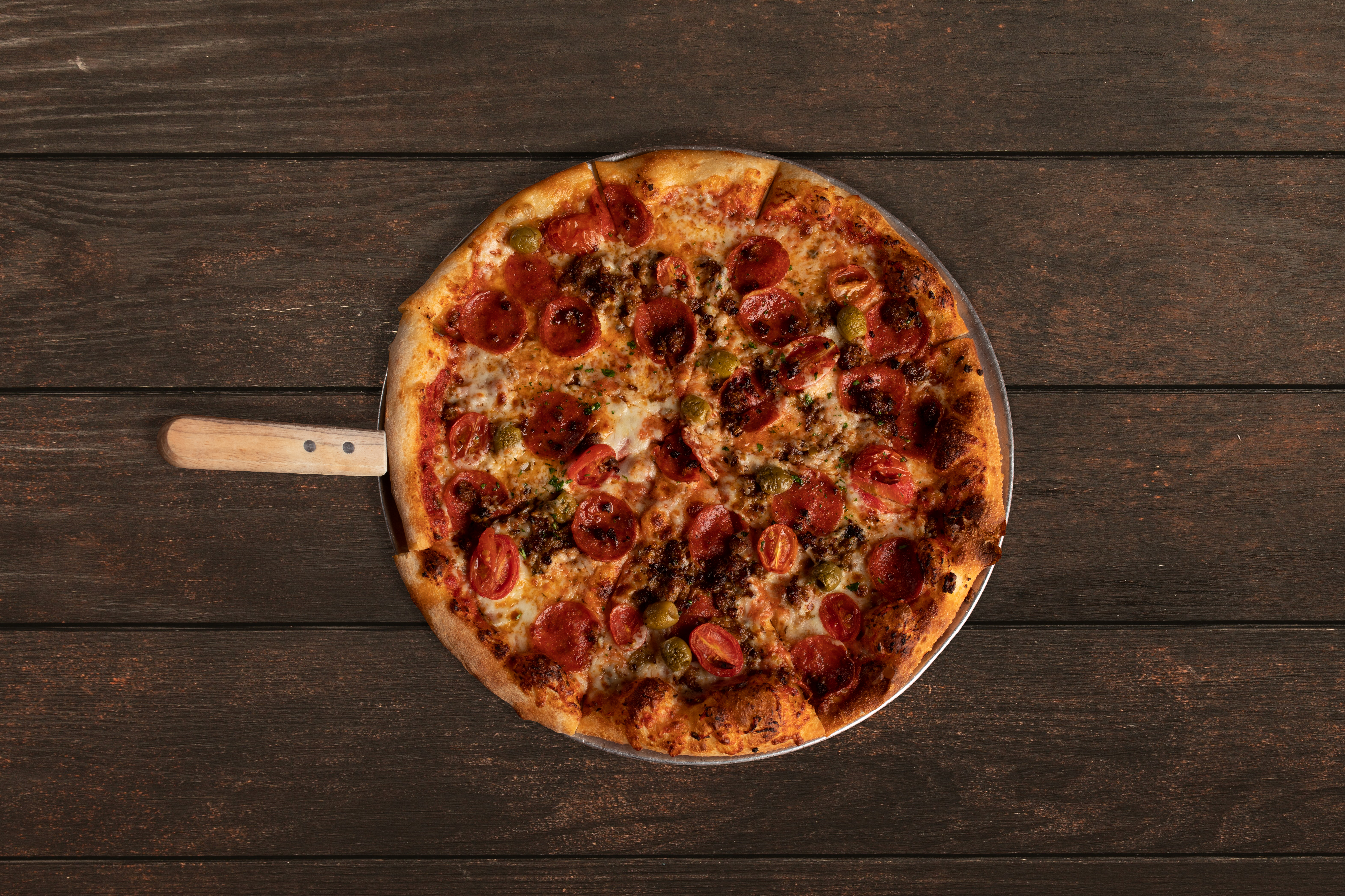a pizza sitting on top of a wooden table
