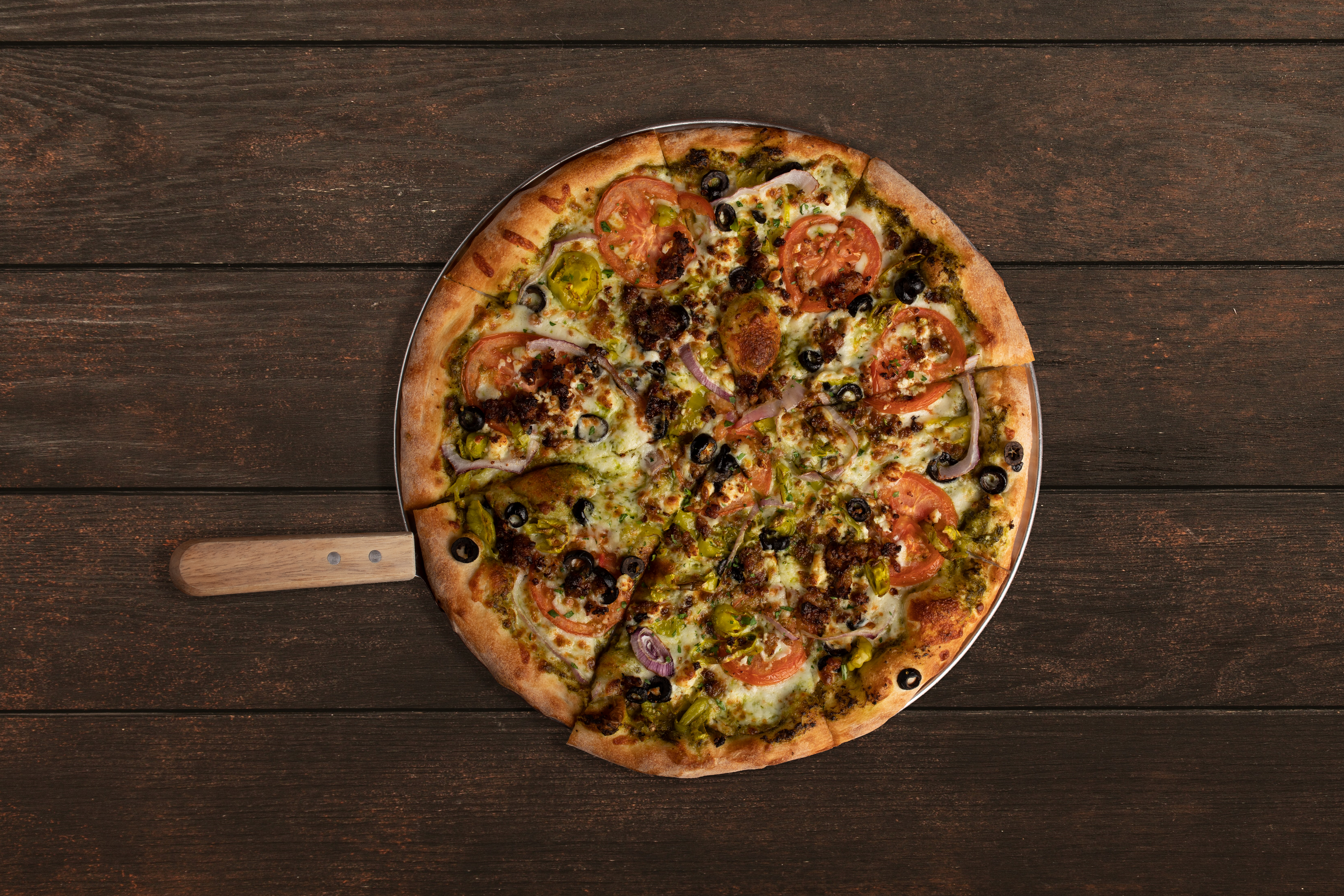 a pizza sitting on top of a wooden table