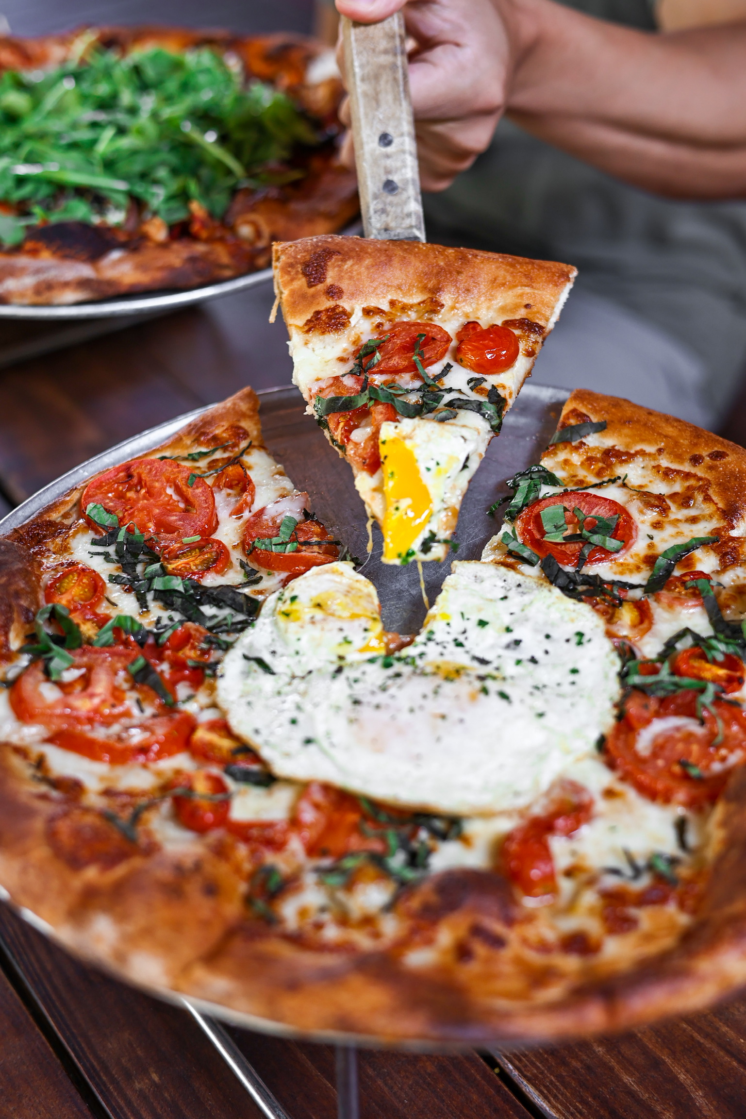 a person holding a slice of pizza