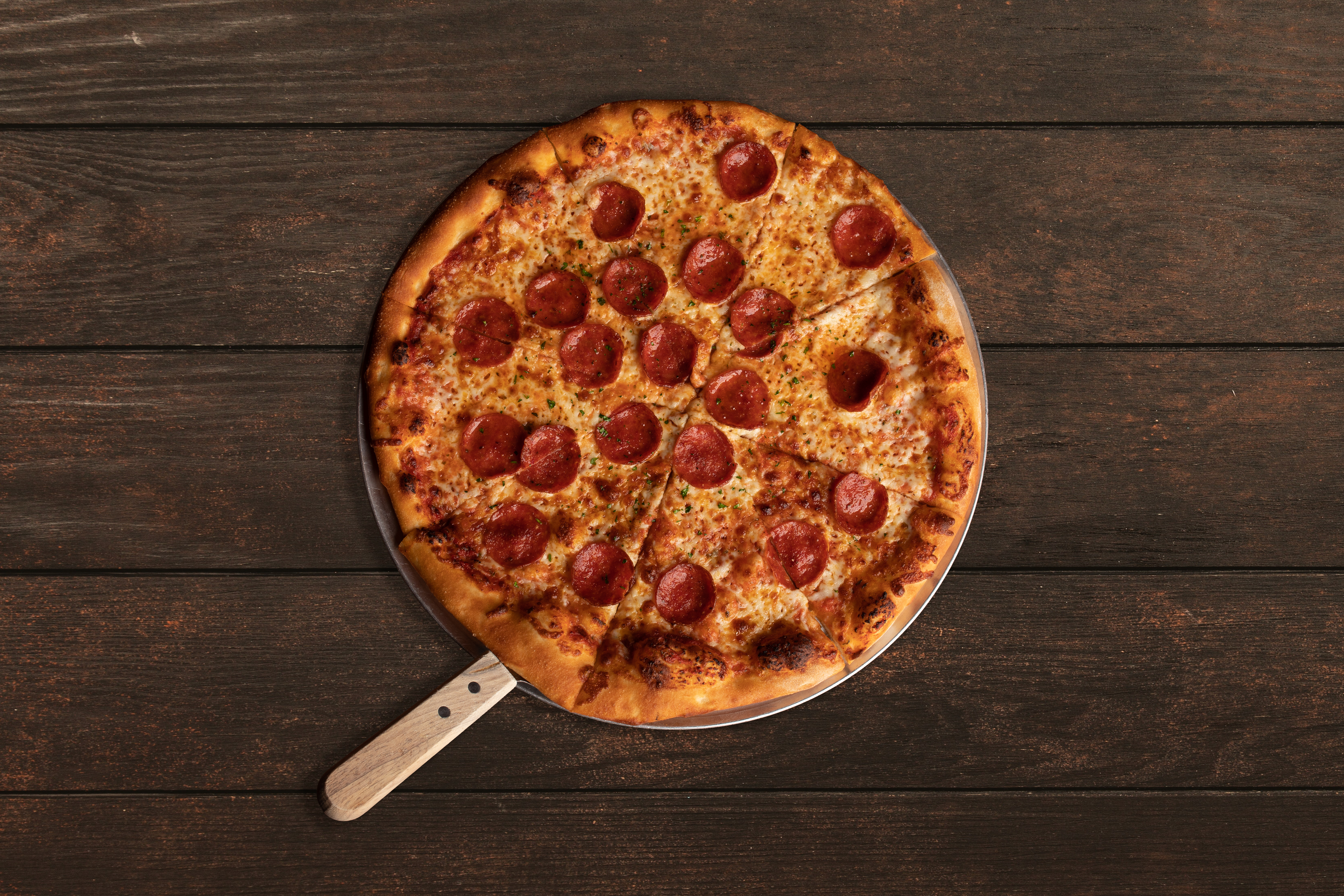 a pizza sitting on top of a wooden table