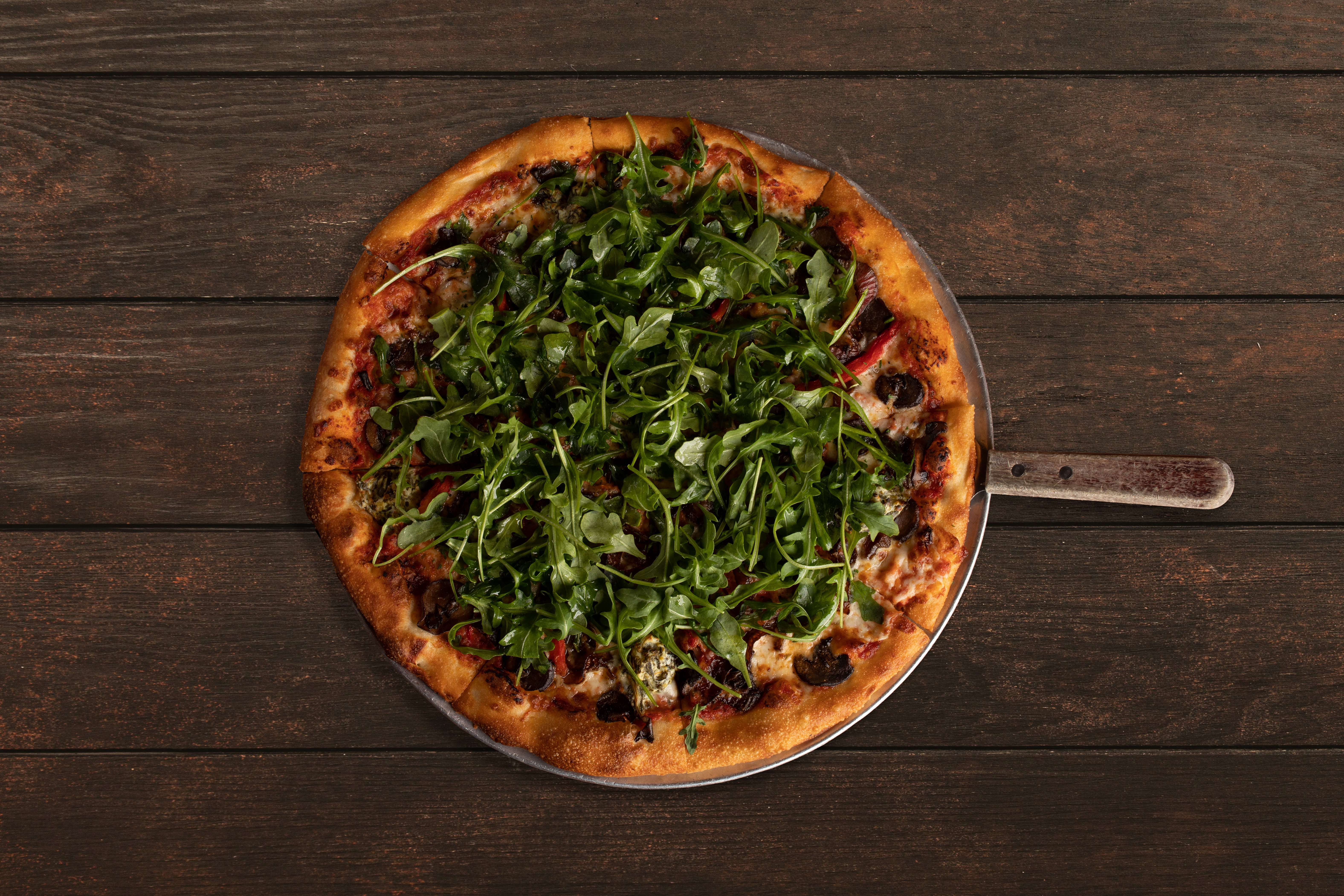 a pizza sitting on top of a wooden table