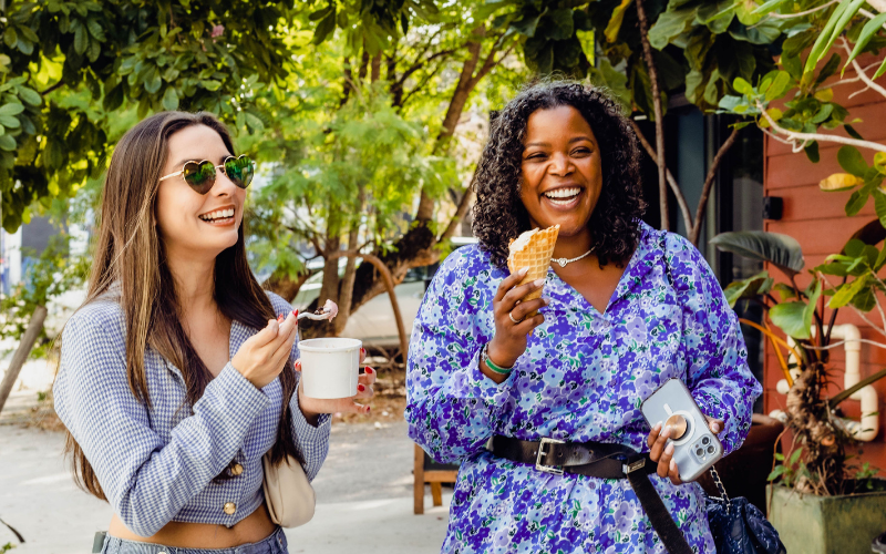 two women holding ice cream and a cup