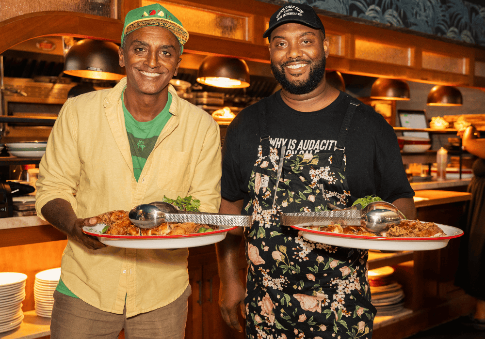 Chef Tristen Epps and Chef Marcus Samuelsson standing in front of the open kitchen at Red Rooster Overtown in Miami, Florida.