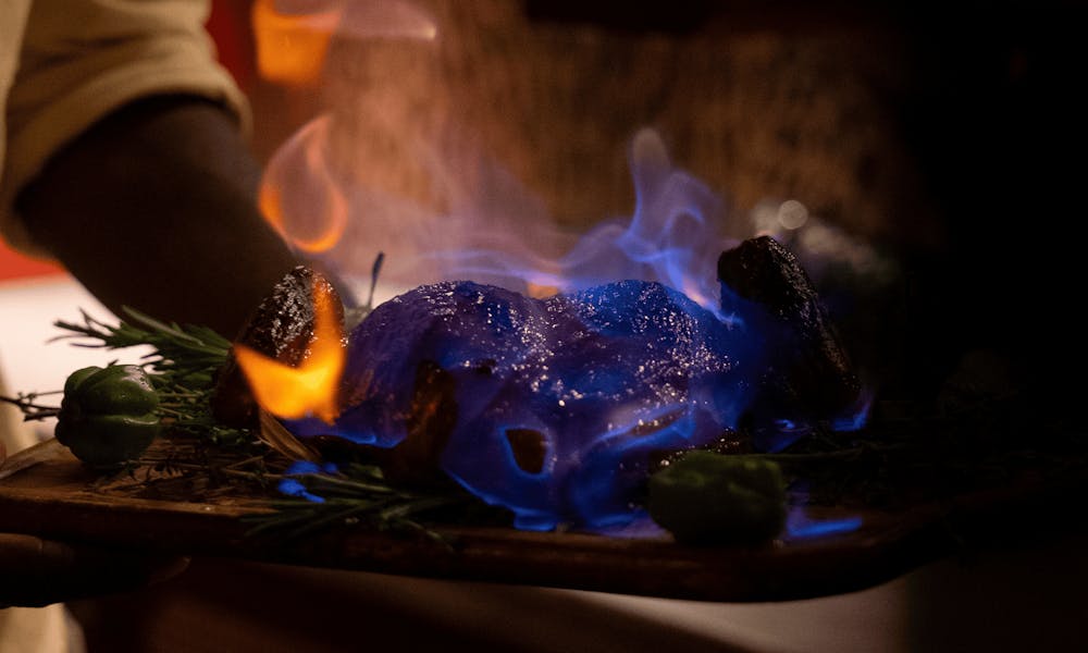 Rooster Royale flaming whole chicken dish served tableside in the private dining room at Red Rooster Overtown during Chef Tristen Epps-Long’s dinner series.