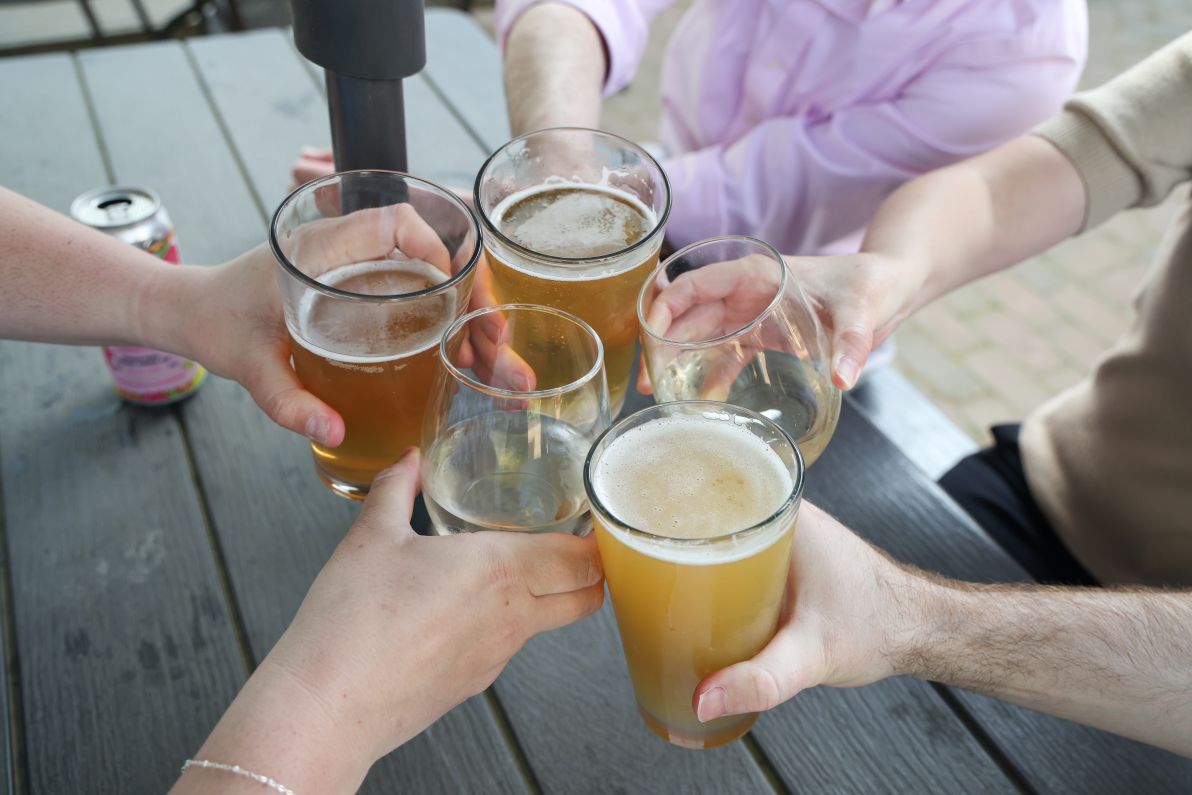a group of people holding glasses of beer