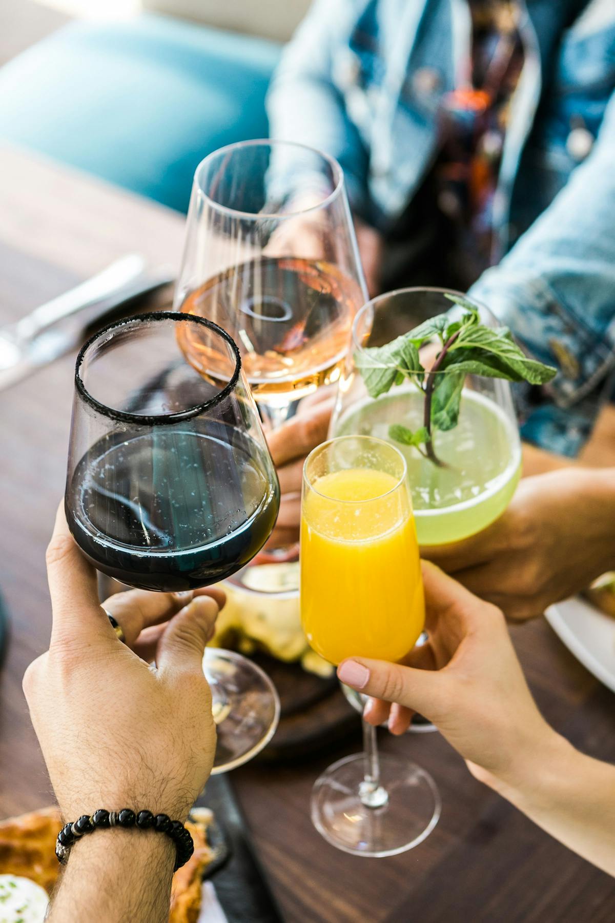 four people cheering with cocktails for mother's day brunch