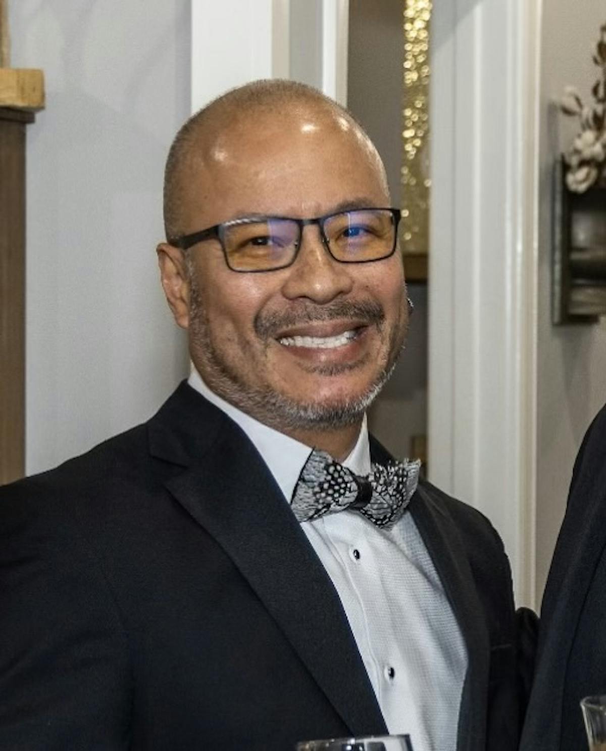 a man wearing a suit and tie smiling at the camera