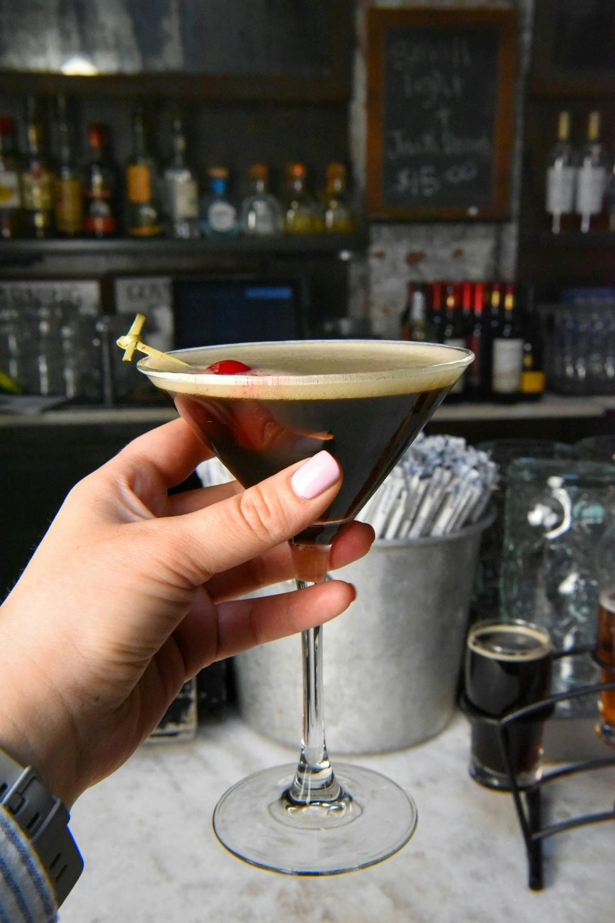 a hand holding a martini glass