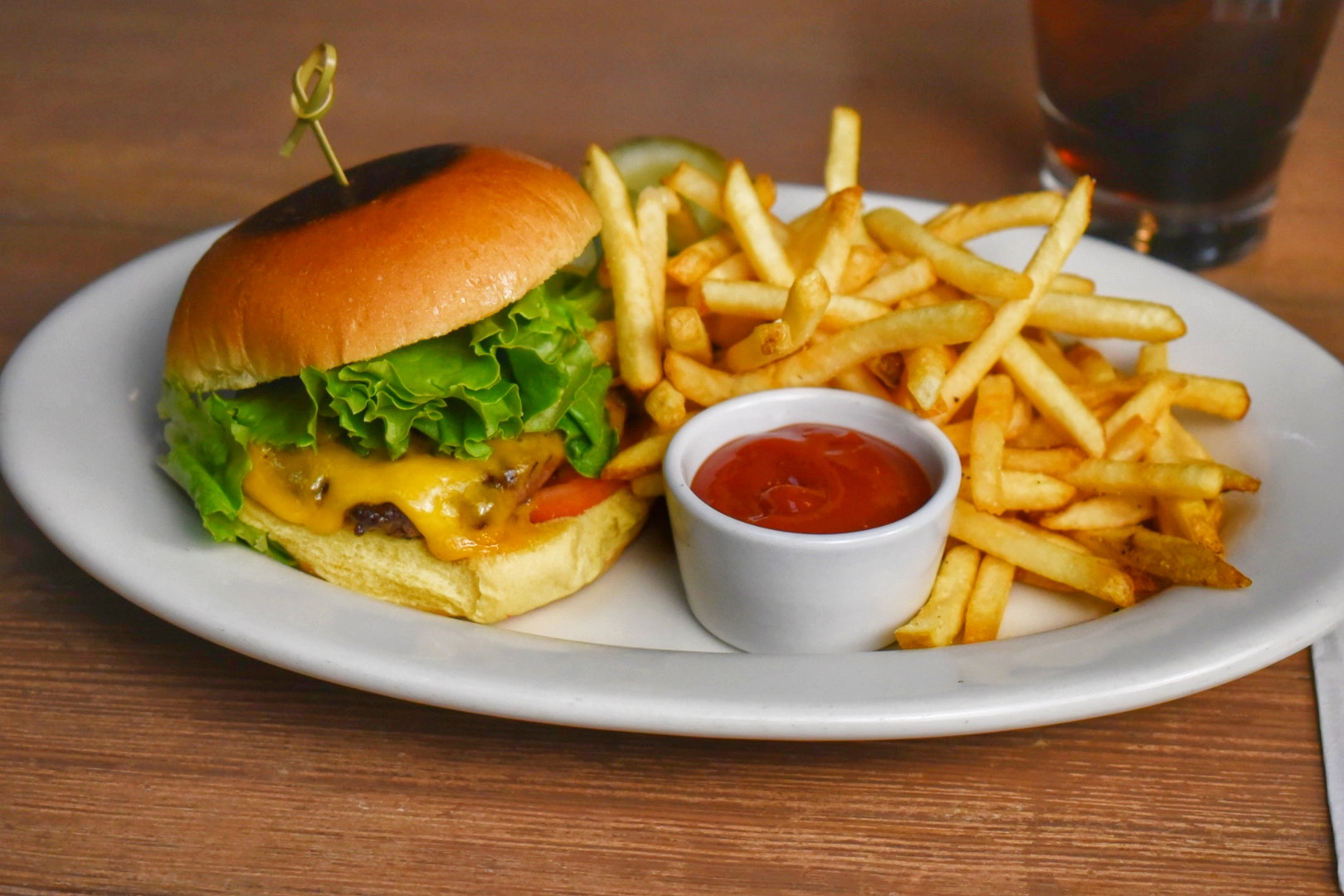 a burger on a plate with fries and ketchup