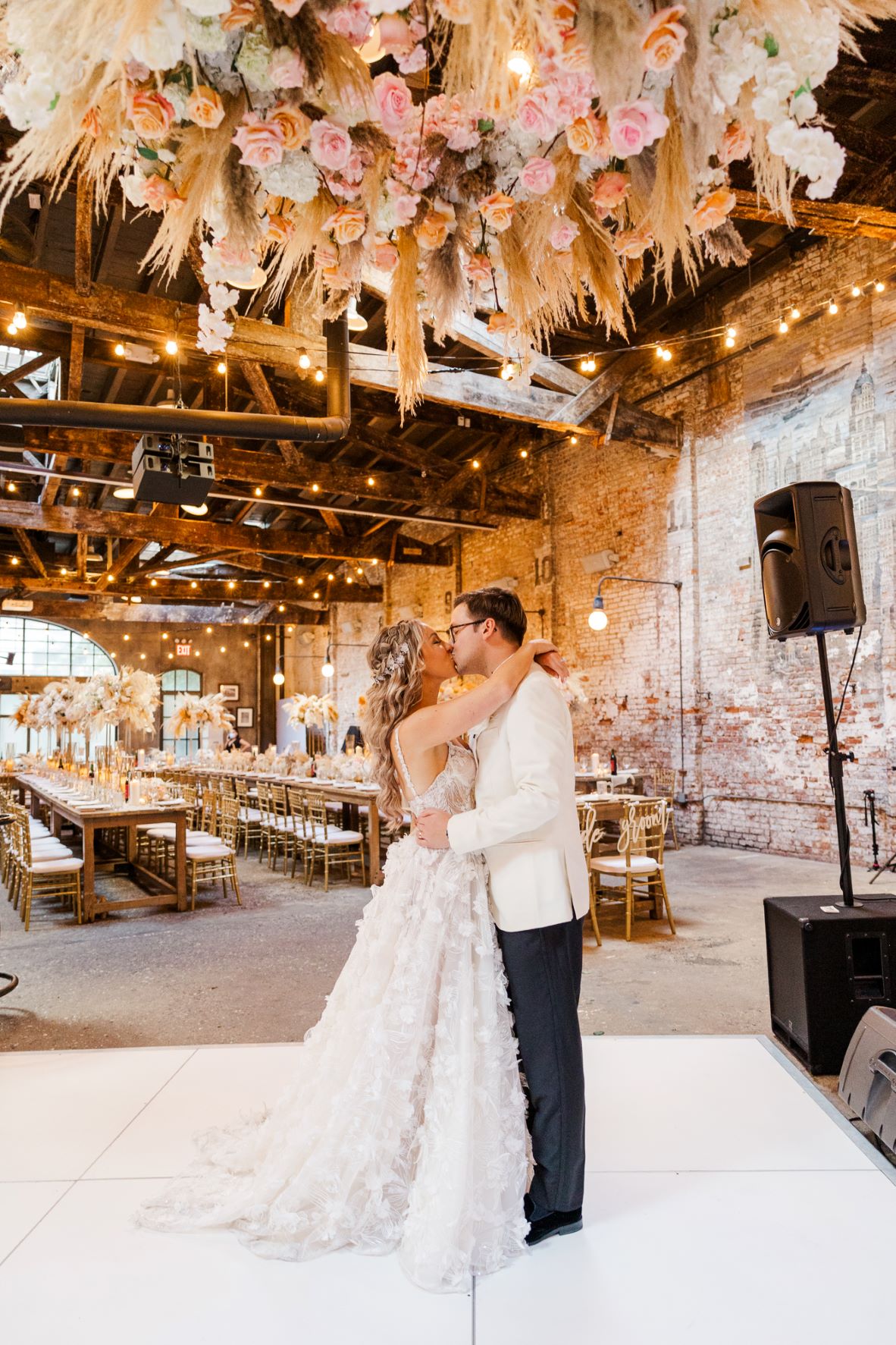 a man and woman kissing in a room with tables and chairs