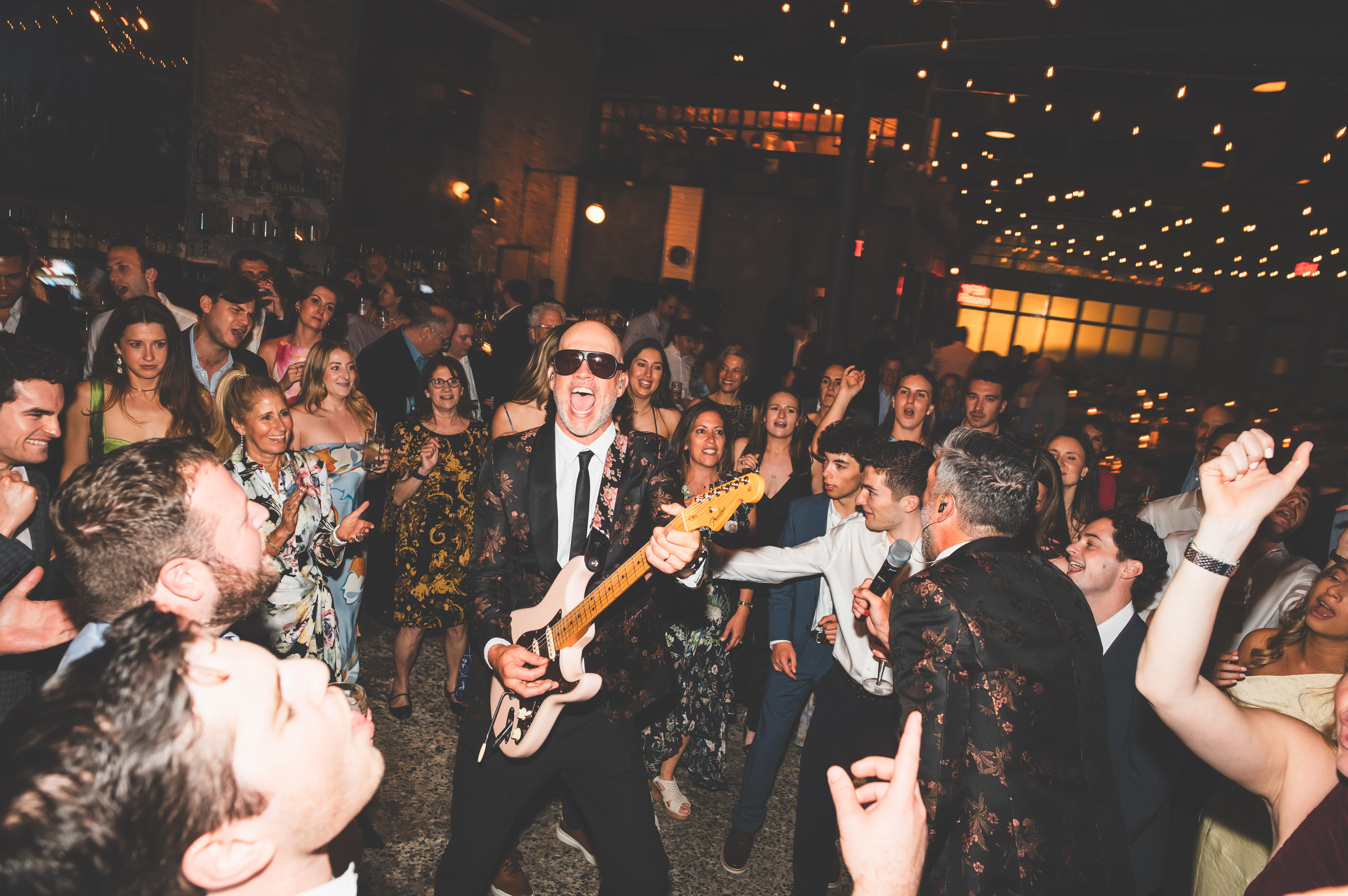 a man playing a guitar in front of a crowd of people