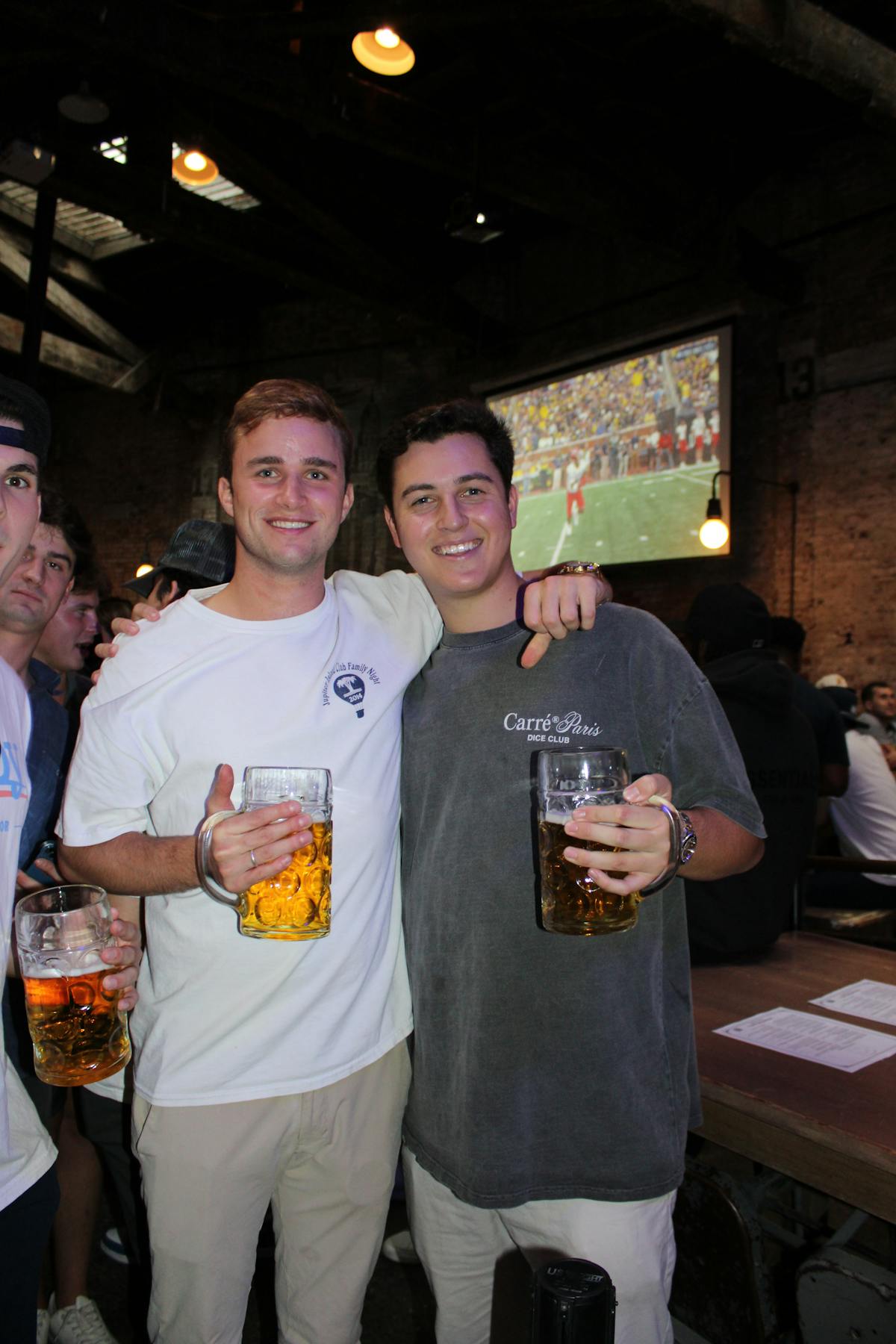 two guys with beer in front of a tv