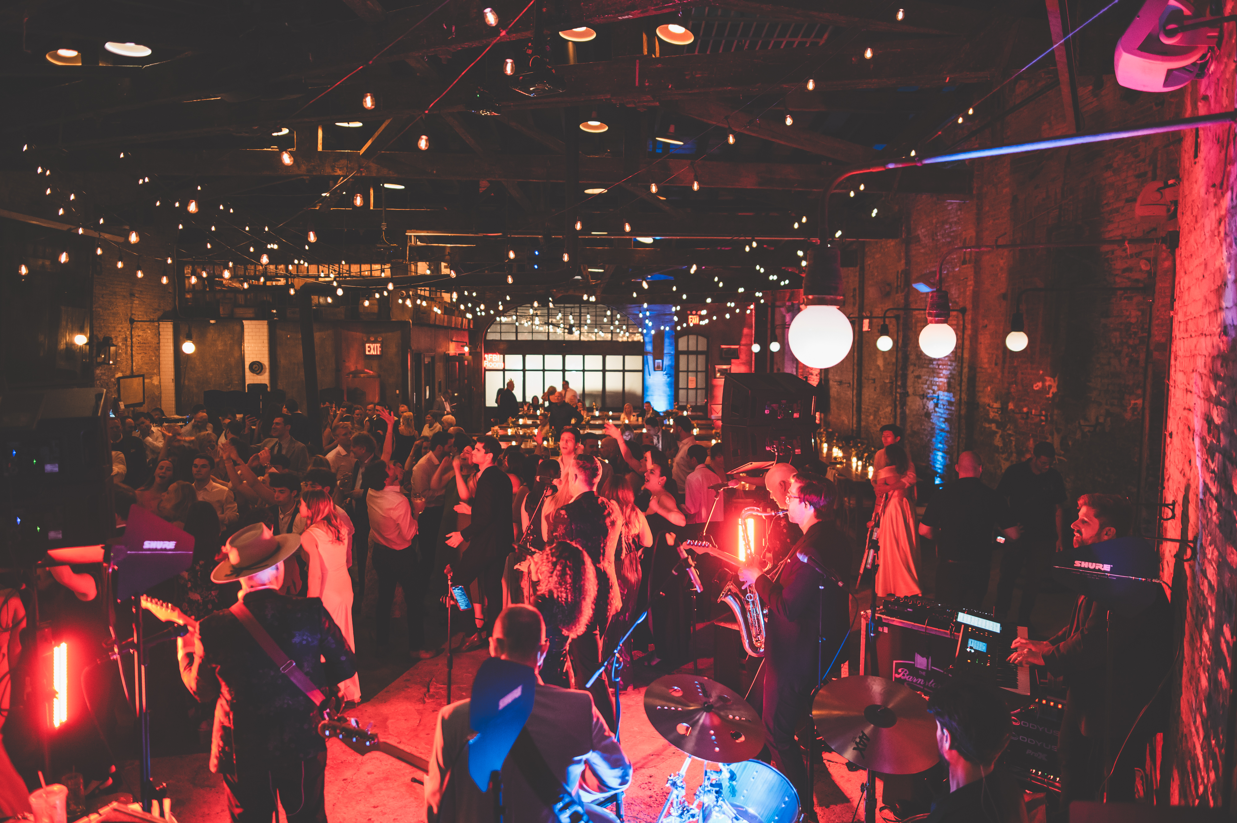 a group of people in a room with a band playing instruments