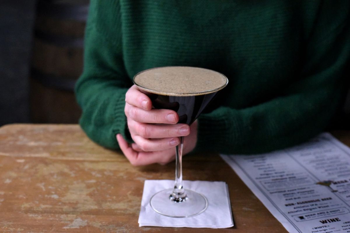 a person holding a glass of liquid
