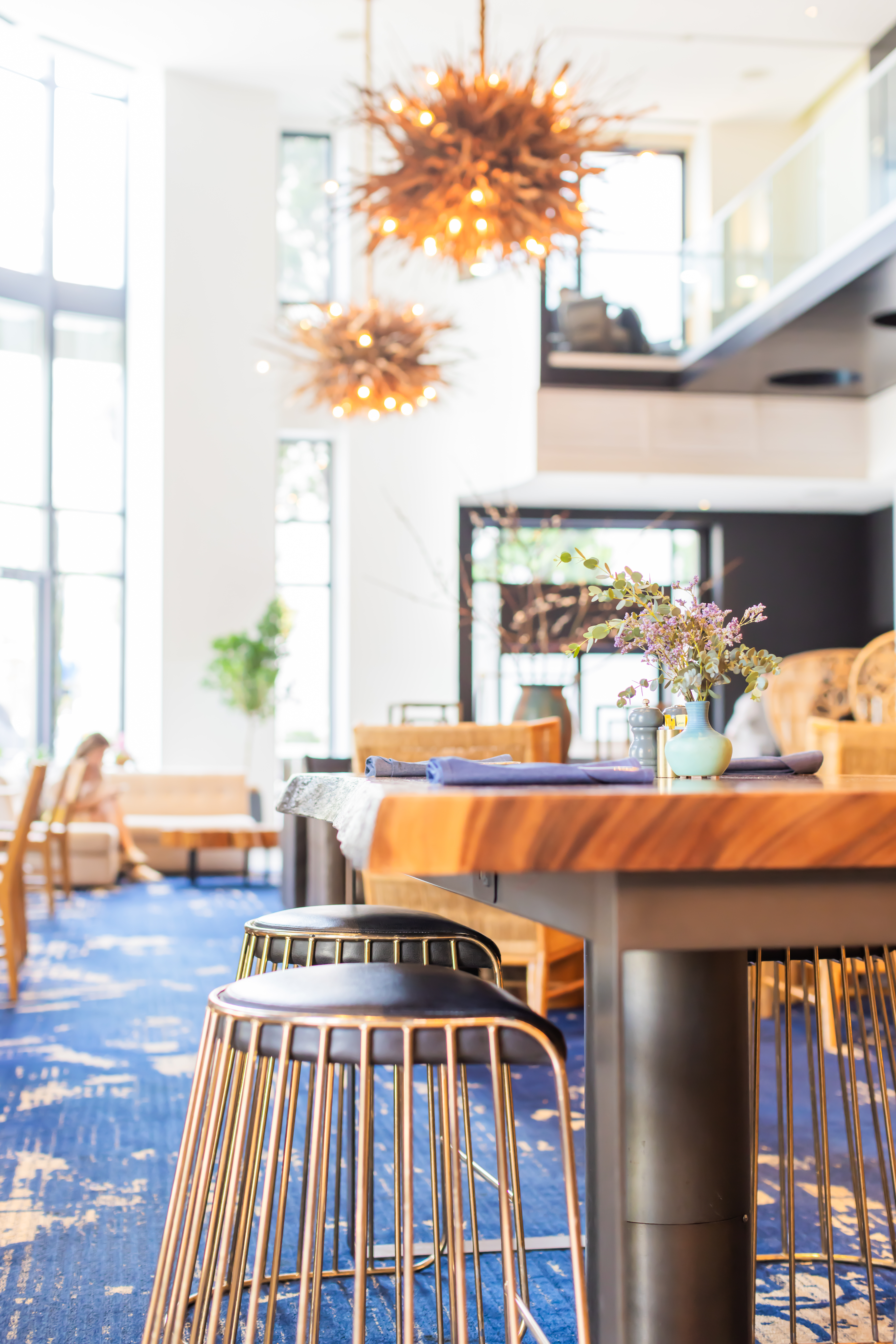 a table with stools and a vase of flowers