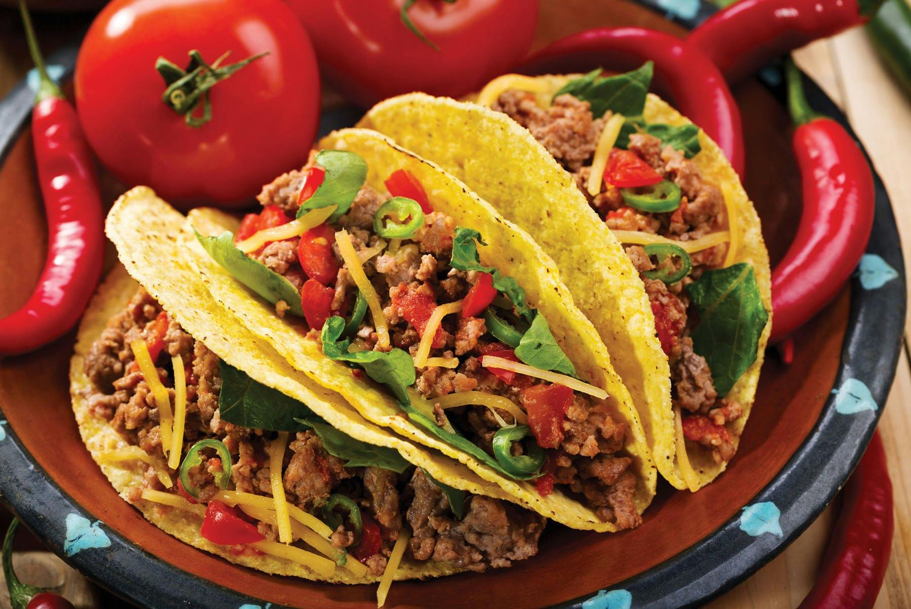 a close up of three tacos on a plate