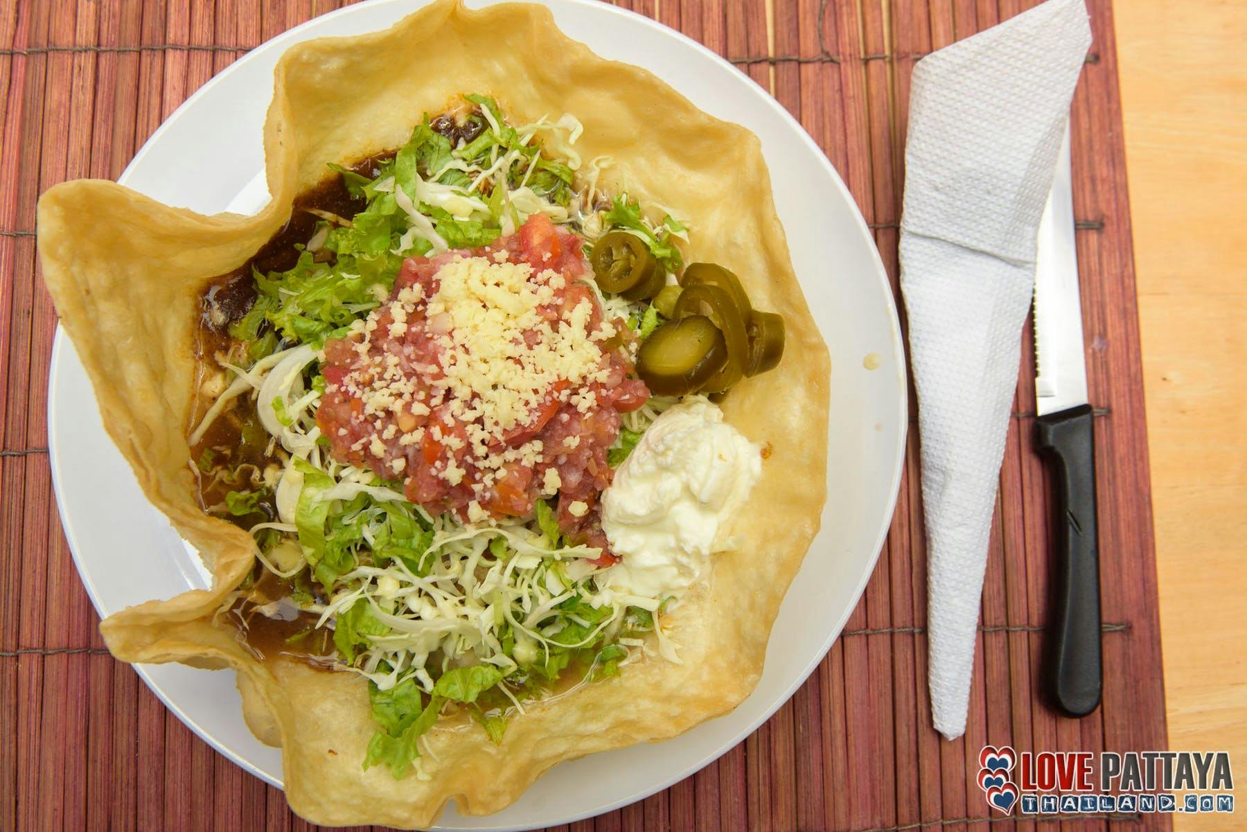 a plate topped with a taco shell and food