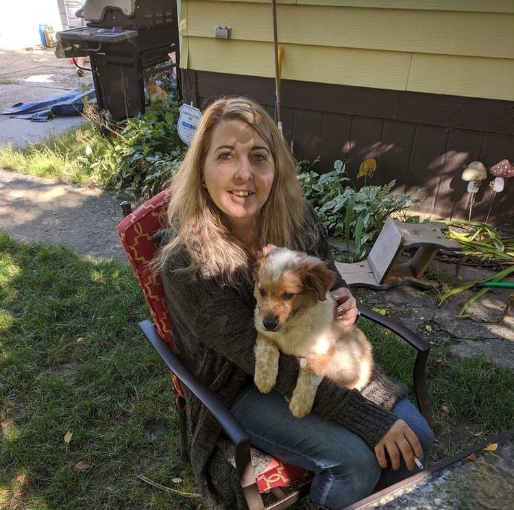 a person holding a dog posing for the camera