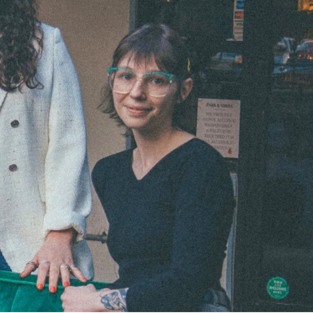 a woman in glasses smiling