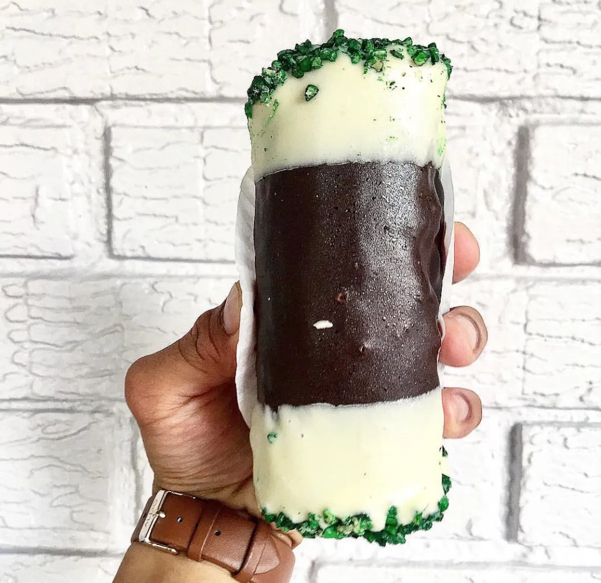 a hand holding a piece of cake
