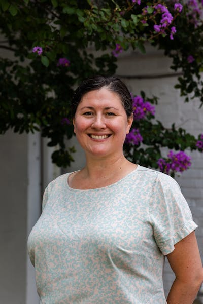 a person standing in front of a flower