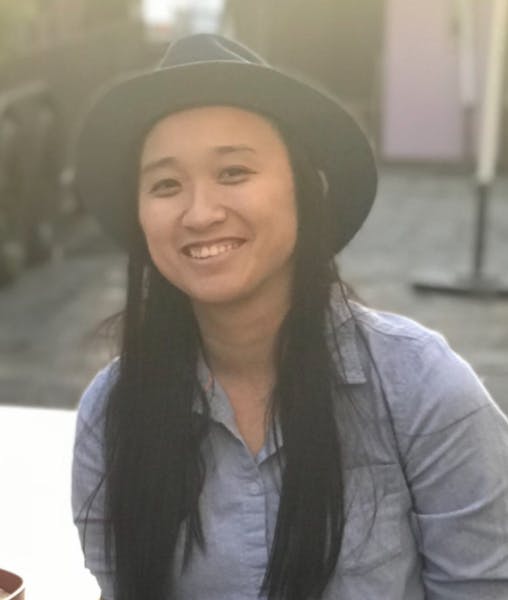 a woman wearing a hat and smiling at the camera