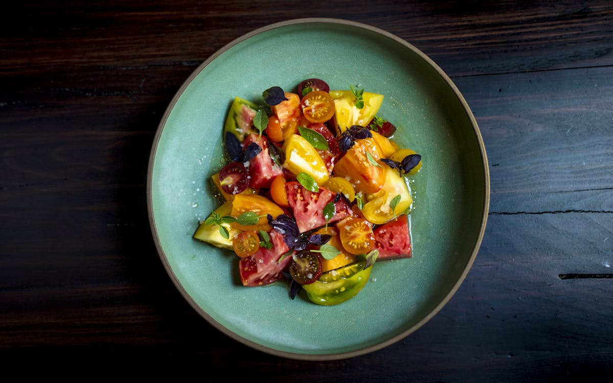 a bowl of fruit sitting on top of a wooden table