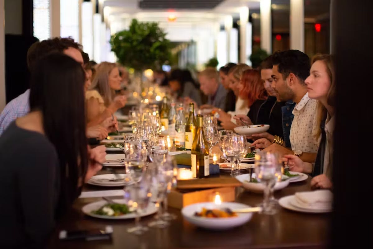 a group of people sitting at a table with wine glasses