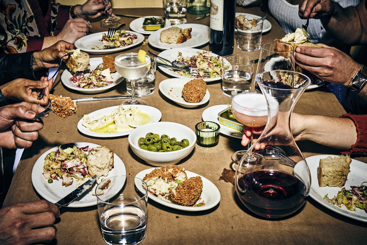 a group of people sitting at a table with a plate of food