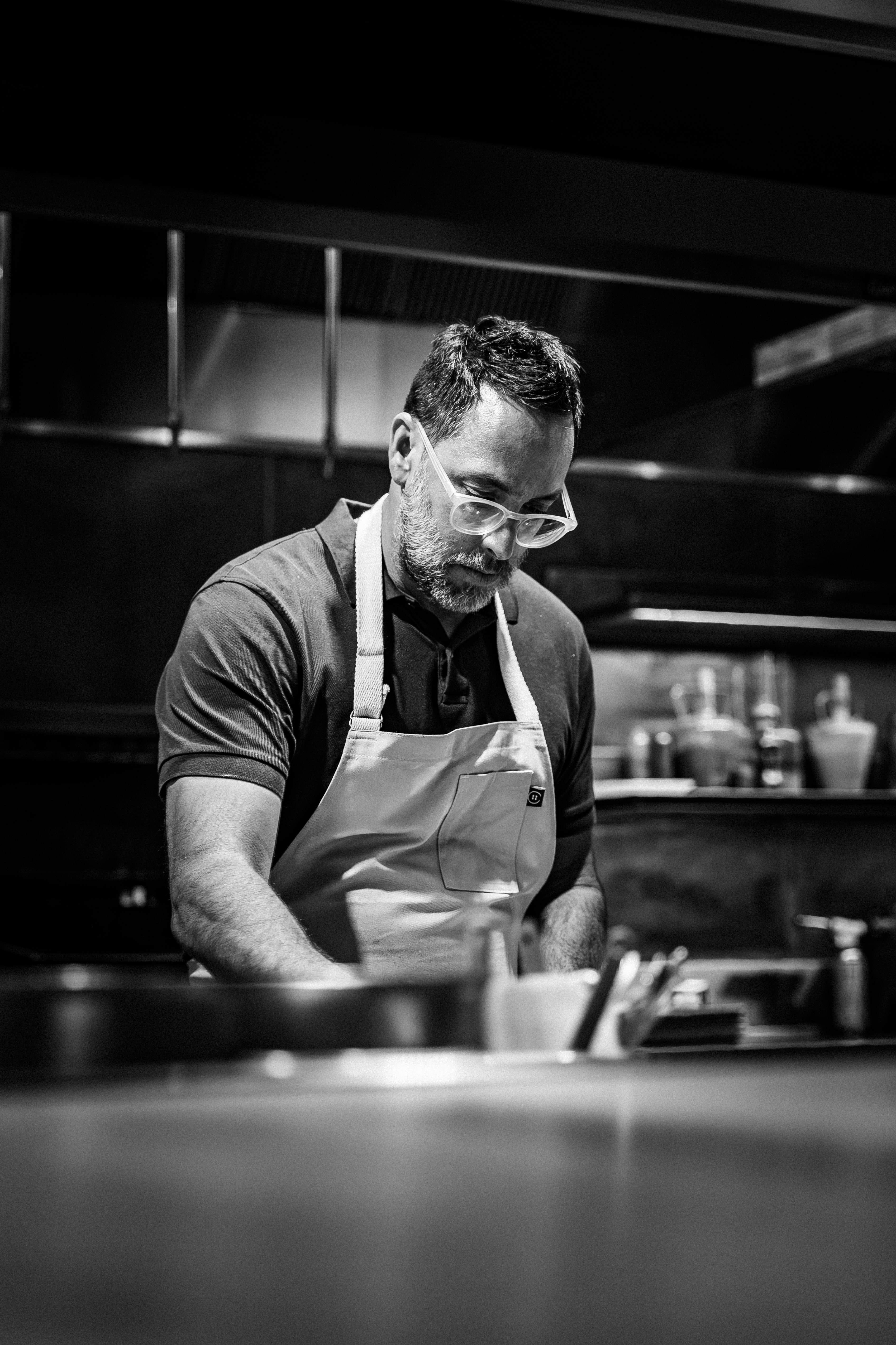 black and white image of chef kostow cooking in the ojai kitchen