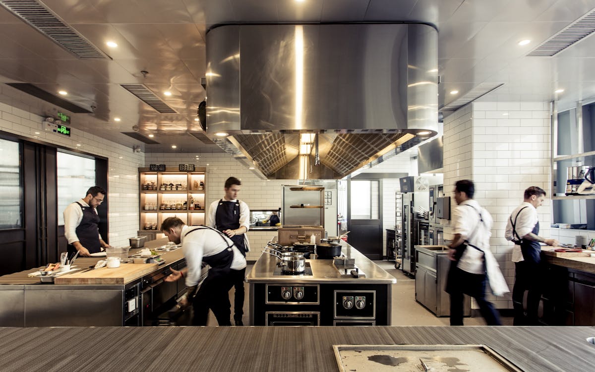 a group of people preparing food in a commercial kitchen