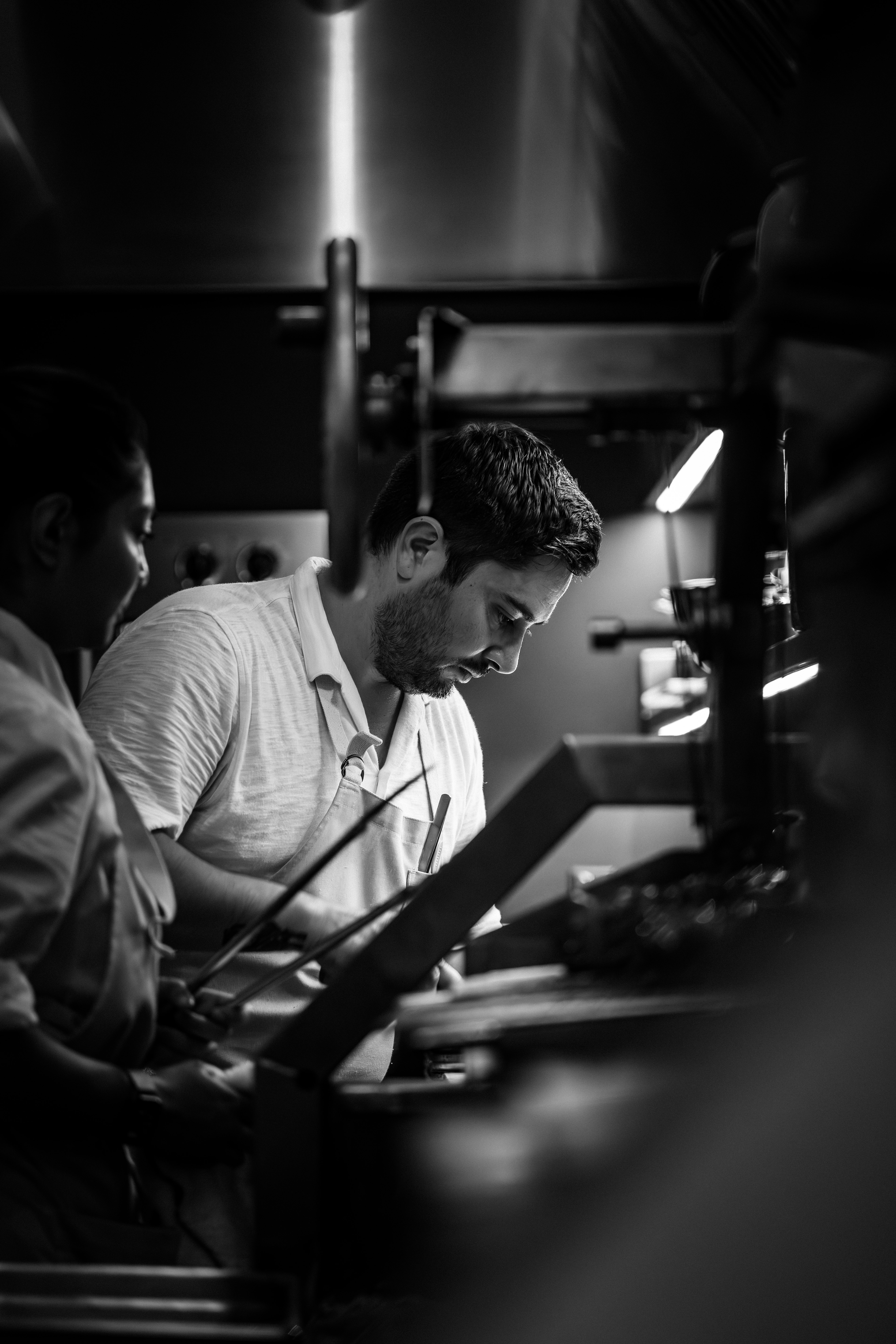 black and white image of Nick razatos, executive culinary administrator, cooking in the ojai kitchen
