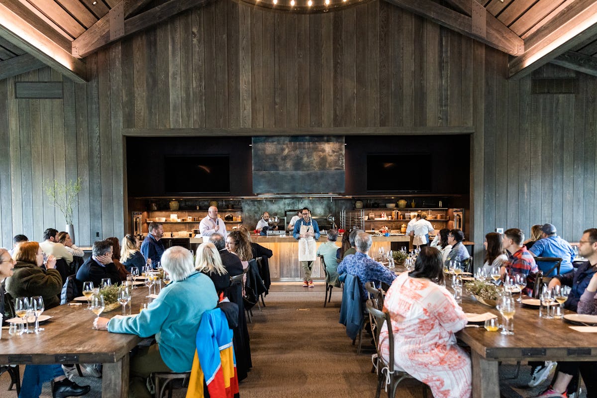ojai valley inn farmhouse with guests sitting inside and chef kostow at the front