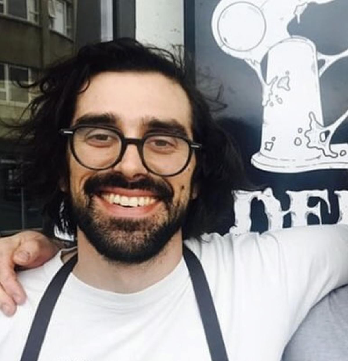a man wearing glasses posing for the camera