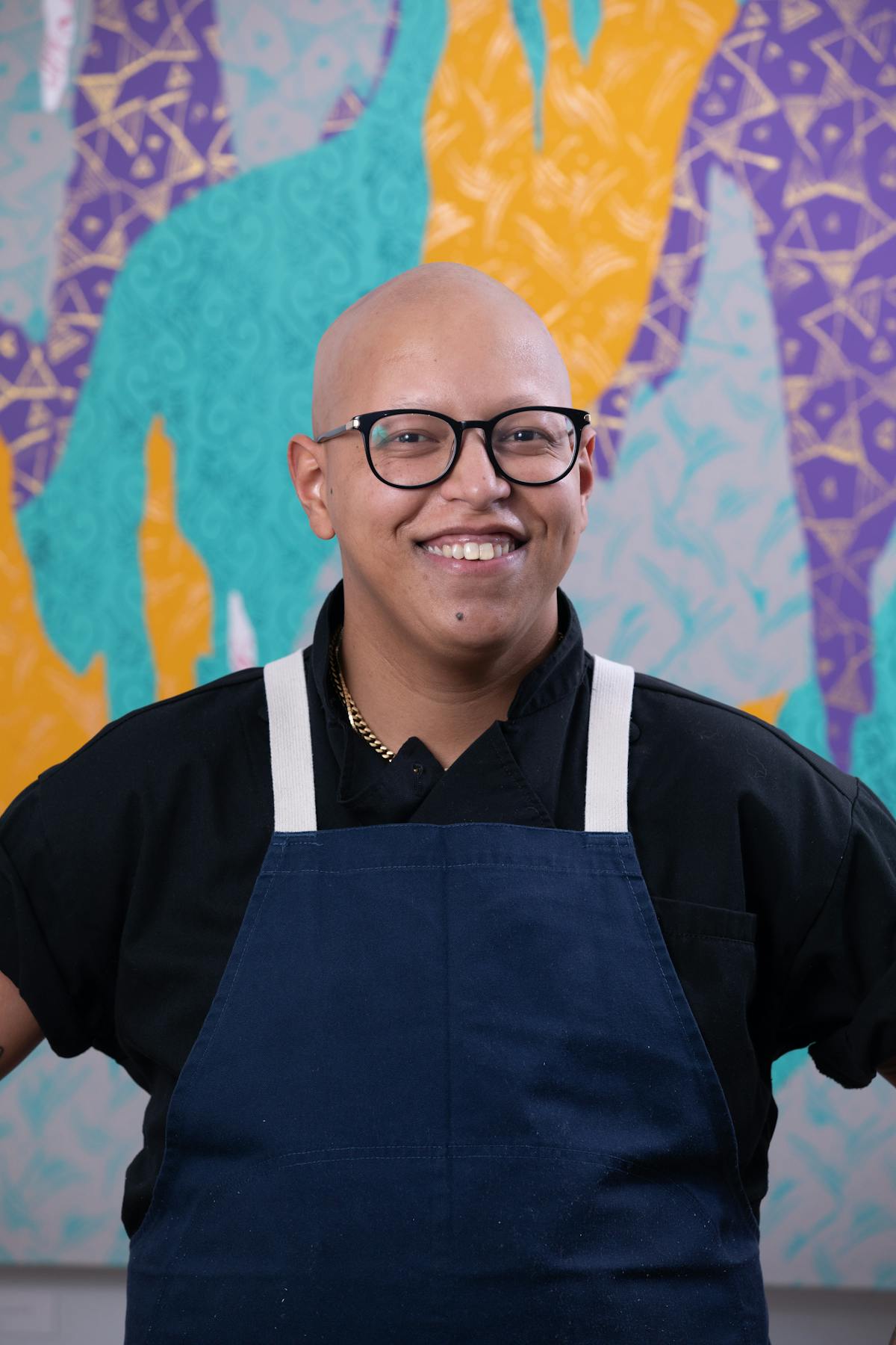 a person wearing glasses and smiling at the camera