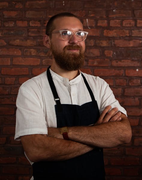 a man standing in front of a brick wall