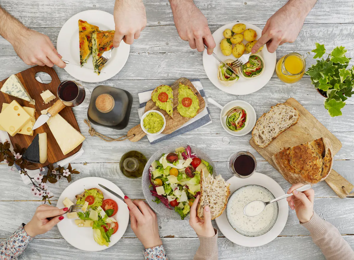 a man holding a plate of food on a table