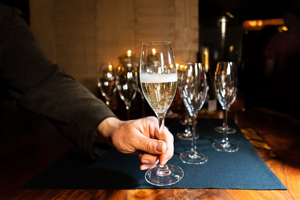 a person sitting at a table with wine glasses