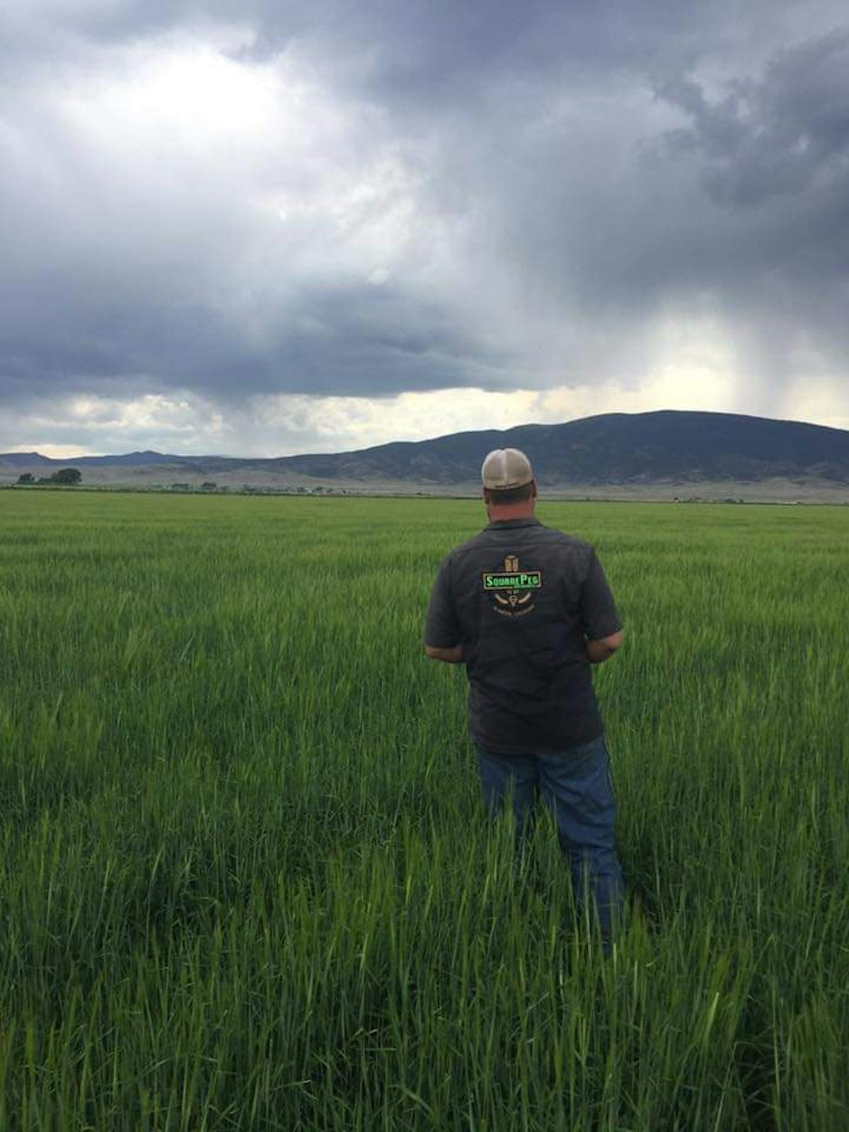 a man standing on top of a grass covered field