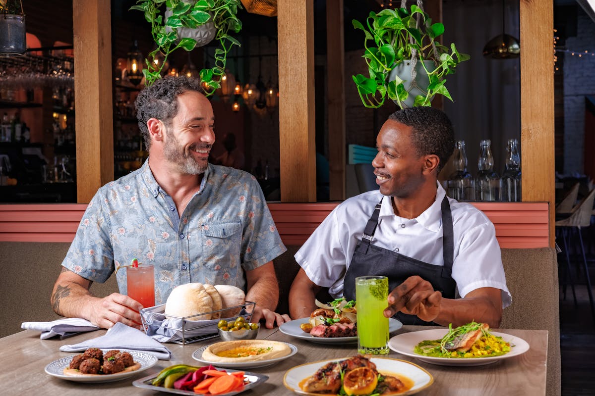 two men sharing mediterranean dishes