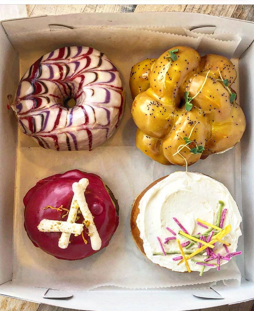 a box filled with different types of doughnuts on a table